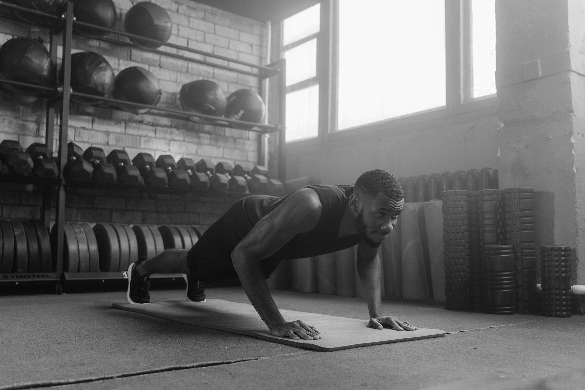 a grayscale photo of a man doing push ups