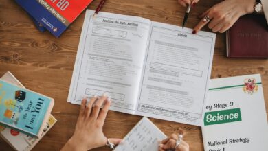 person writing notes on her notebook